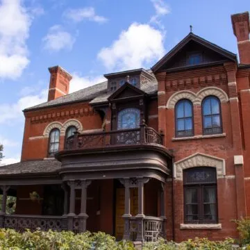 Front of Dalnavert Museum, which has a verandah, arched windows and a dormer.