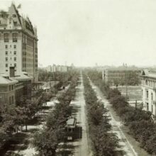 Image 1: A view down Broadway lined with trees featuring a street car and the Fort Garry Hotel to the left, 1916