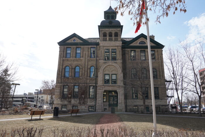 Isbister School with a flagpole flying the Canadian flag in front of it.