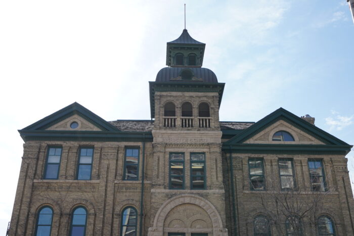 The top half of the Isbister School front facade with “ISBISTER SCHOOL” carved into the stone.