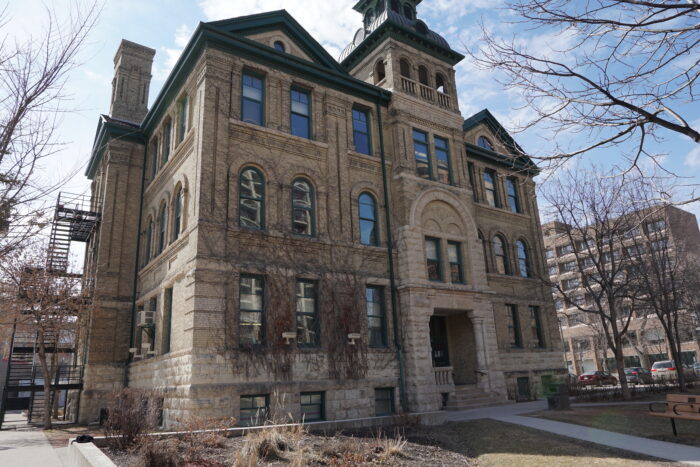 Isbister School with vines growing up the facade. A fire escape is on the side of the building.