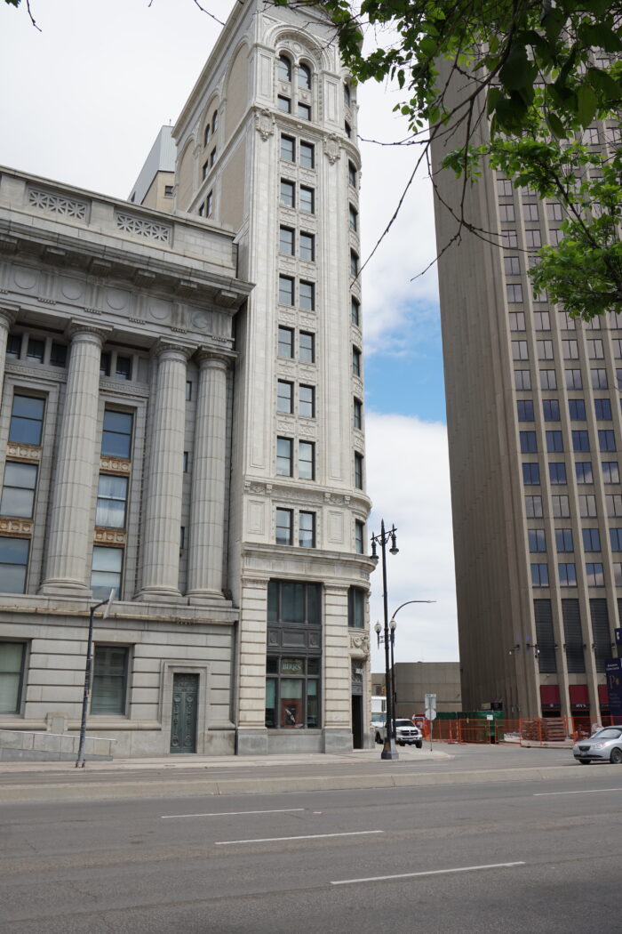 The Union Trust Building as seen from across the street. Buildings are visible on both sides of it.