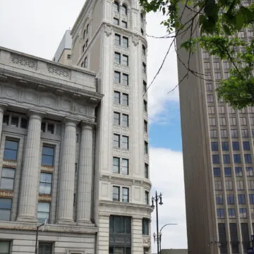 The Union Trust Building as seen from across the street. Buildings are visible on both sides of it.