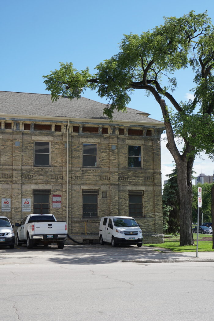 Vehicles parked in front of façade.