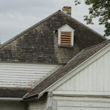 Image 8: Details of the roof of the Seven Oaks House featuring a dormer window and a small chimney upon grey roof tiling