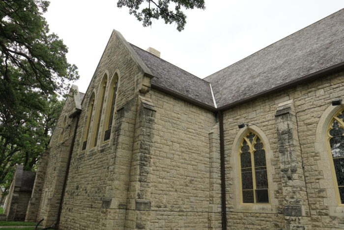 The side facade of Winnipeg’s St. John’s Cathedral with trees growing beside it.