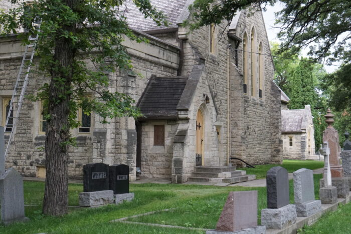 Facade of St John's Cathedral with multiple grace markings in view on the grass in front of the building