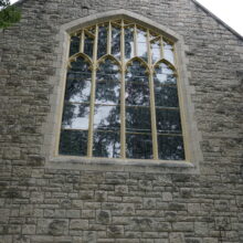 Image 9: Facade of St. John's Cathedral featuring a large gothic style glass paned window with decorative details on the frame