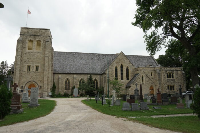 The side facade of Winnipeg’s St. John’s Cathedral with a cemetery in front.