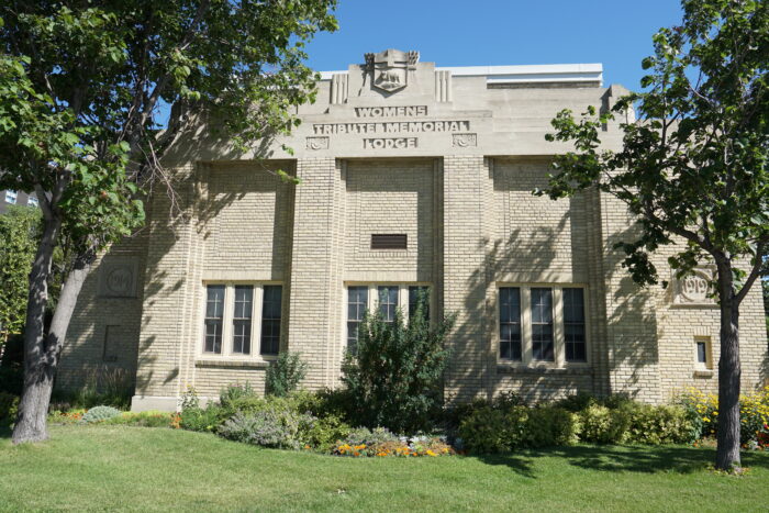 The Women’s Tribute Memorial Lodge with the Coat of Arms of Manitoba and “WOMENS TRIBUTE MEMORIAL LODGE” on the facade.