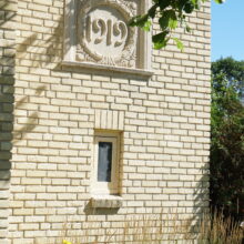 Image 1: Ornamental details with the year 1919 inscribed, on the side of the building