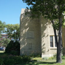 Image 2: Facade of the Women's Tribute Memorial Lodge in the shade of a tree