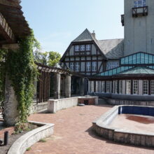 Image 2: The back facade of the Assiniboine Park Pavilion with an empty pond in front of it.