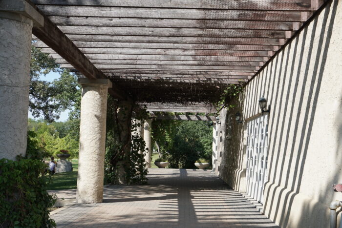 Vines grow over a pergola running alongside the Assiniboine Park Pavilion.