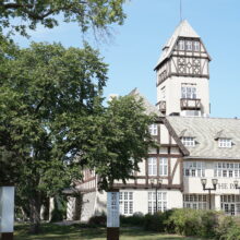 Image 4: Front facade of Assiniboine Park Pavilion with trees obscuring view on the left