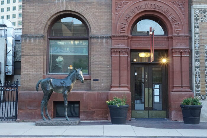 The Lake of the Woods Building with the number “212” on the door and a horse sculpture in front.