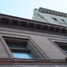 Image 7: Looking up at the facade of the building with a focus on the detail on the cornices