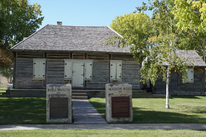 Ross House with two stone signs flanking the front sidewalk, reading “ROSS HOUSE” and “MAISON ROSS.”