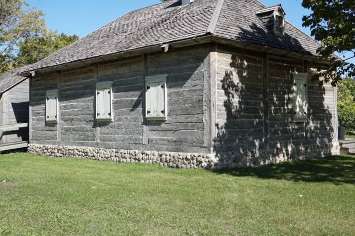 The back of Ross House with all the shutters closed. Trees grow in the background.