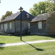 Image 6: A view of Ross House and a detached shed with a light post in front