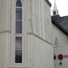 Image 4: Narrow gothic style arched windows against the facade of the building