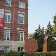 Image 5: Hexagon shaped sign on the side of the path leading to St. Boniface City Hall front entrance