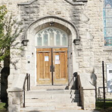 Image 1: Steps up to a set of wooden doors on the Westminster Avenue side of the building