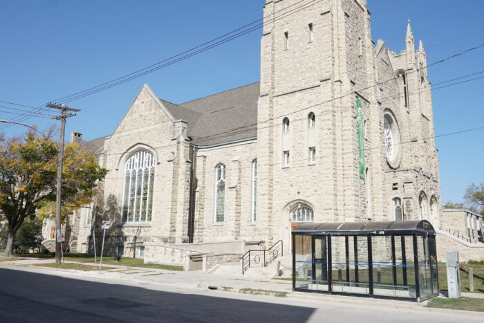 Winnipeg’s Westminster Church with a bus shelter on the sidewalk in front of it.