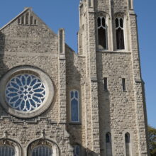 Image 4: Facade of the building facing Maryland Street featuring the right-handside tower and rose-window detail above the main doors