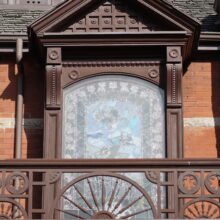 Image 8: Stained glass window behind second floor balcony