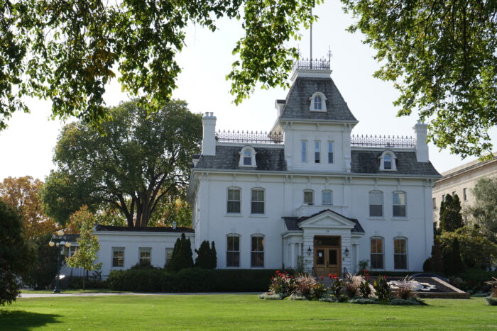 Government House with a hedge and flower bed in front.