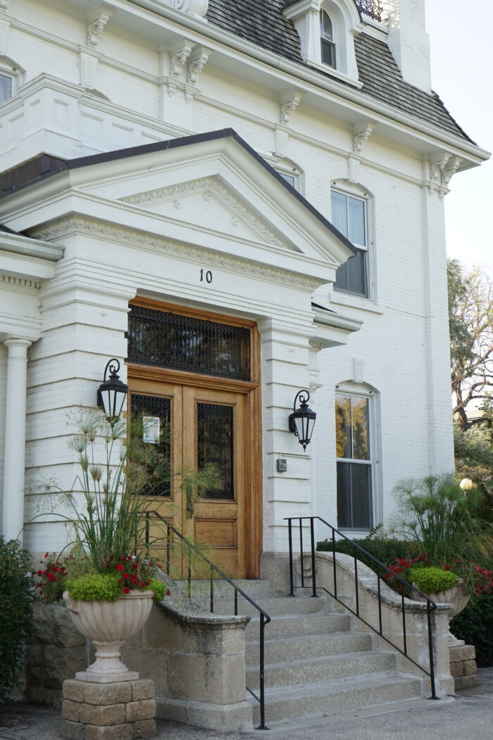 The front entrance to Government House with the number “10” above the door. Planters flank the steps.