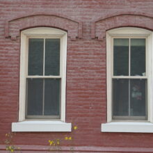 Image 5: A pair of main floor windows with arched stone trim