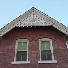 Image 6: A pair of stone trim windows under an ornate gable