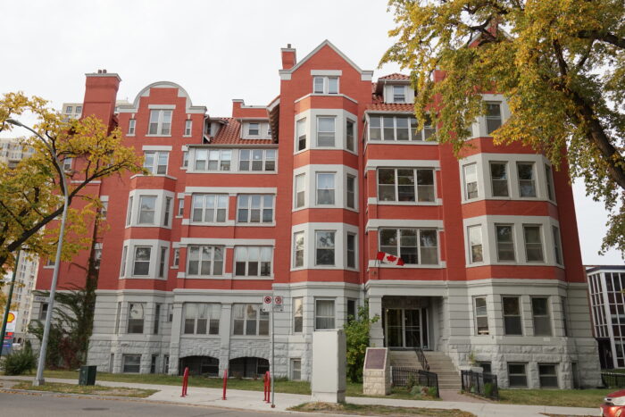 Roslyn Court Apartments with a Canadian flag mounted above the front entrance.