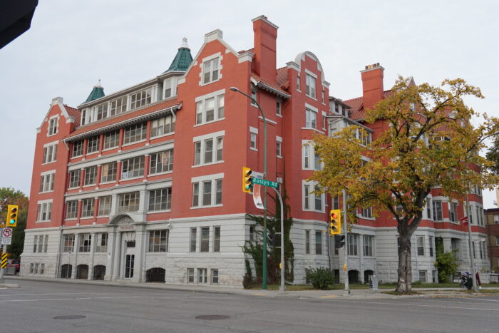 The Roslyn Court Apartments. A stoplight with a sign reading “Roslyn Rd” is in front.