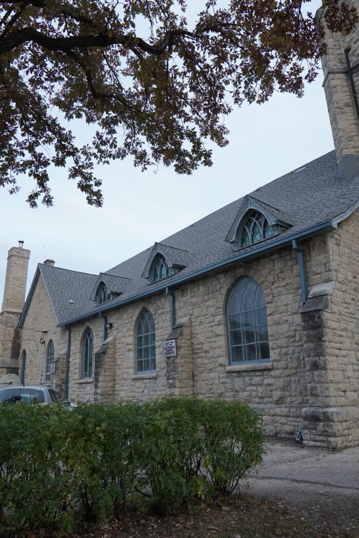 Three large pointed arched windows below a roof featuring three dormers