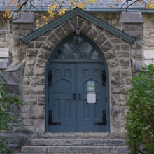 Image 11: Small stone steps leading up to one of the wooden side doors into St. Luke's Church