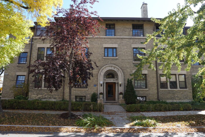 The front of the Wardlaw Apartments with trees partially obscuring the facade.