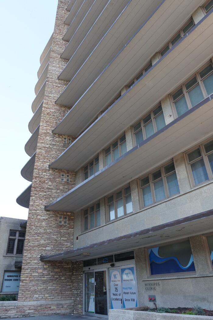 The front entrance of the Winnipeg Clinic building with “WINNIPEG CLINIC” posted next to the door.