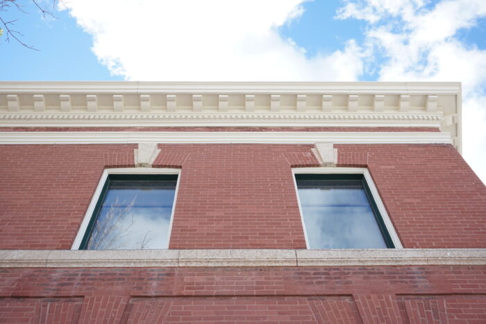 Looking up at two windows on the second floor of the Selkirk Post Office.