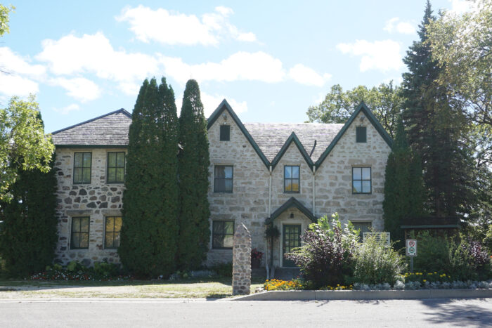 Kennedy House viewed from across the street. In front of the building are a pillar and no parking sign.