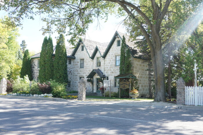 Kennedy House with landscaping obscuring part of the facade. A sign reads “Captain Kennedy House.”