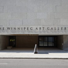 Image 3: Main entrance of the Winnipeg Art-Qaumajuq with a sign above that reads "The Winnipeg Art Gallery"