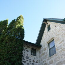 Image 2: Looking up at single window and roof peak.