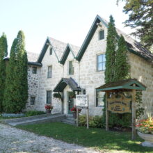 Image 3: Kennedy House viewed from across the street. In front of the building are a pillar and no parking sign.