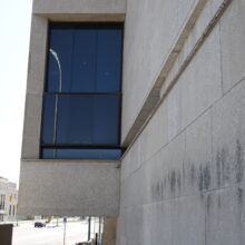 Image 6: Details of a window on the facade of the original Winnipeg Art Gallery building viewed from the sidewalk looking towards Memorial Boulevard south