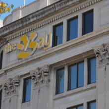 Image 5: Modern yellow sign near the top of the building that reads "The Bay"