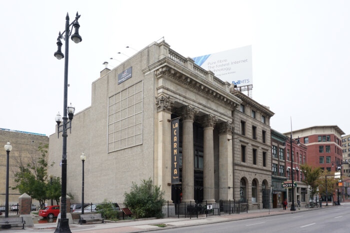 Side of Winnipeg’s Bank of Toronto building viewed from across the street with three other buildings on the right.