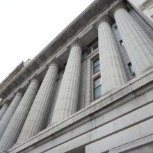 Image 5: Looking up at the facade of the Canadian Bank of Commerce featuring columns and architectural details